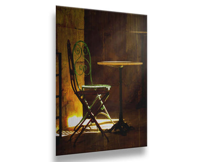 A photo of chairs around a small table, illuminated by light pouring in through the window. Printed on metal.