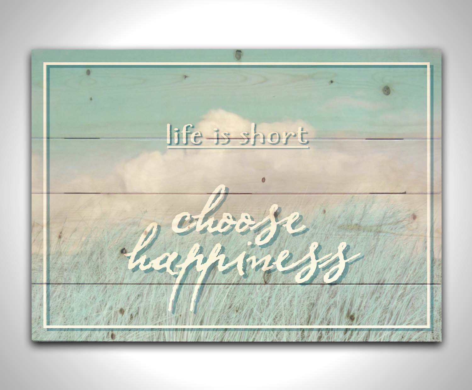 A photo of tall grass under a blue sky with white clouds. The phrase "Life is short, choose happiness" is superimposed on the image. Printed on a wood pallet.