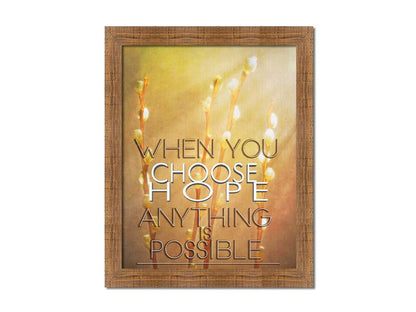 A photo of four stems of plant buds bathed in golden light. The phrase "When you choose hope, anything is possible" is superimposed on the center. Printed on canvas and framed.