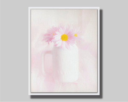 A photo of a white vase with pink daisies in a soft pink background. Printed on canvas in a float frame.