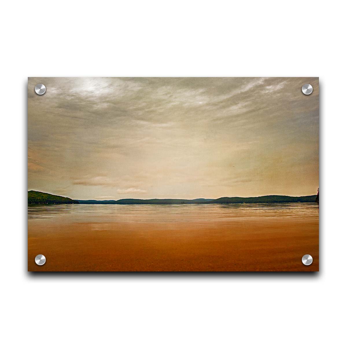 A photograph looking out at the sea and sky. The sky is cloudy and a warm gray, while the sea reflects a brilliant orange. Coastlines of trees can be seen in the distance. Printed on acrylic.