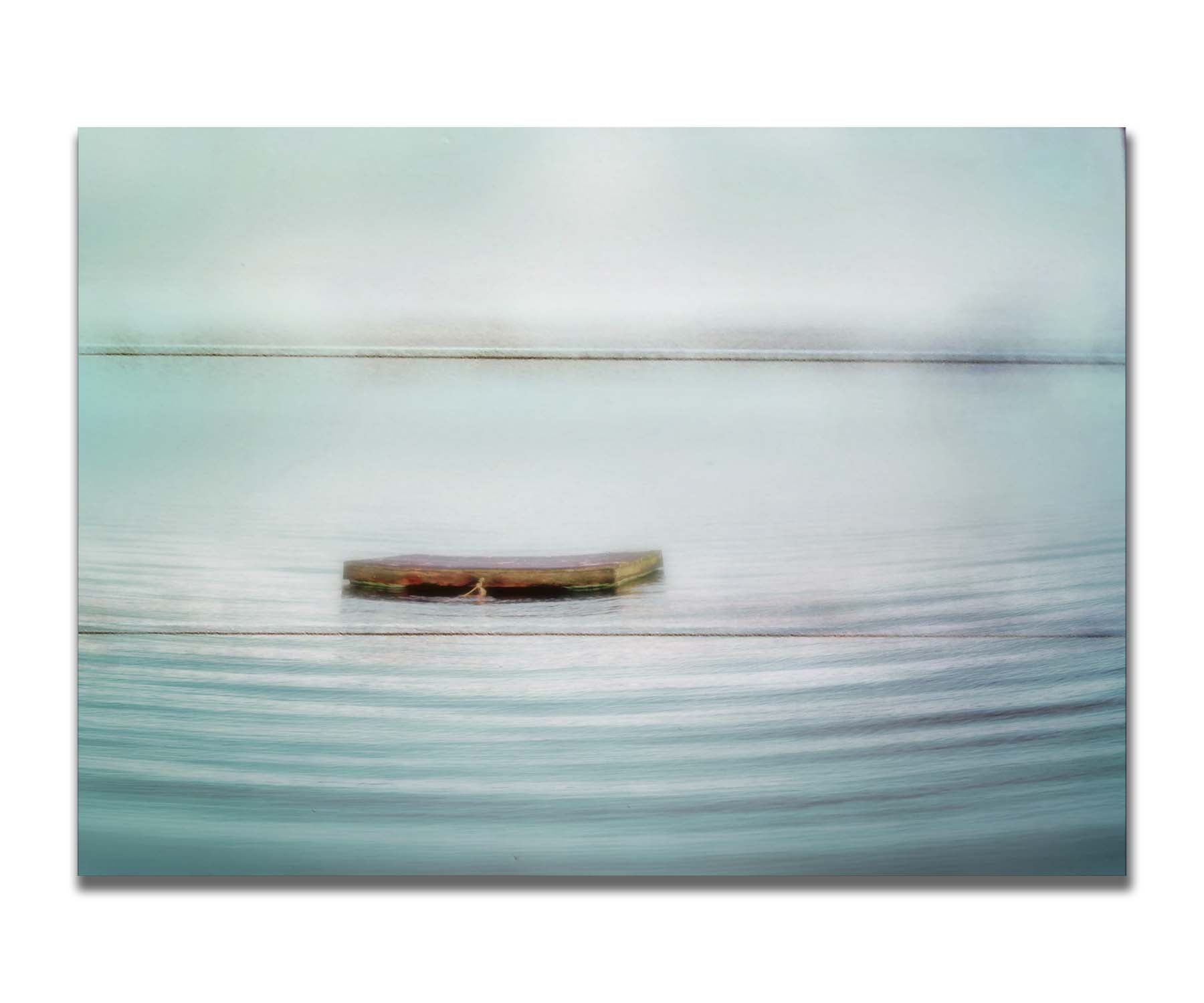 A photo of a small square dock floating on the water. The sky and water blur together. Printed on a box board.