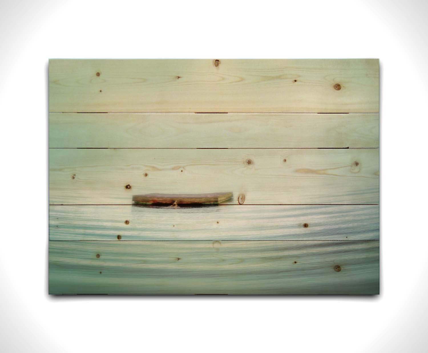 A photo of a small square dock floating on the water. The sky and water blur together. Printed on a wood pallet.