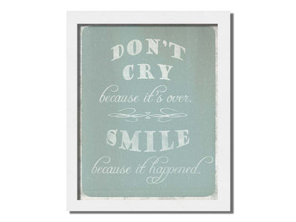 A typography design reading "Don't cry because it's over, smile because it happened" in white on a blue background. Printed on canvas and framed.