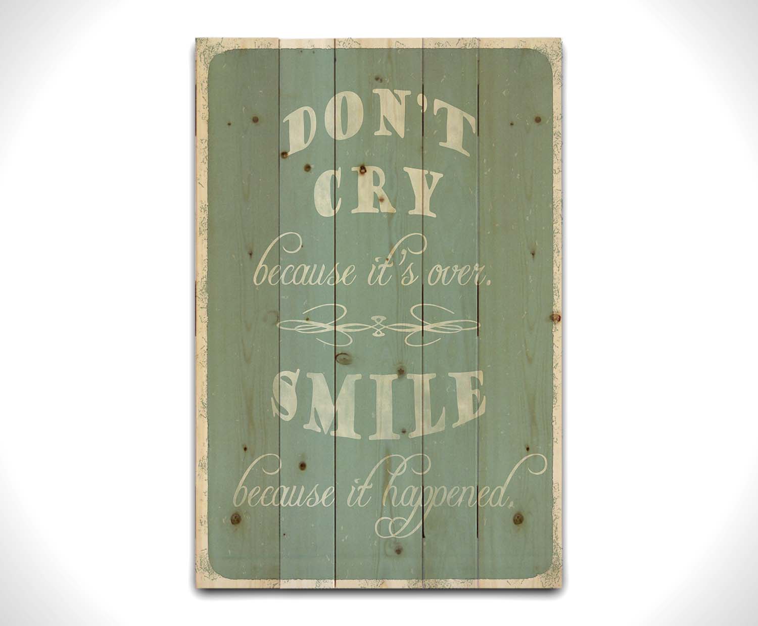 A typography design reading "Don't cry because it's over, smile because it happened" in white on a blue background. Printed on a wood pallet.