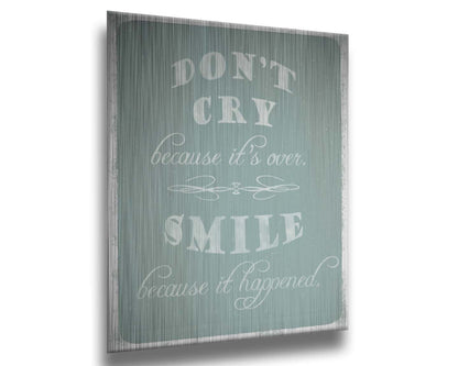 A typography design reading "Don't cry because it's over, smile because it happened" in white on a blue background. Printed on metal.