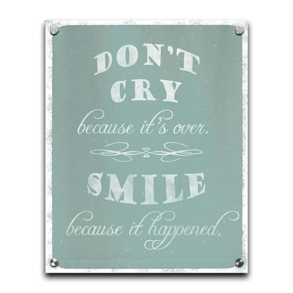 A typography design reading "Don't cry because it's over, smile because it happened" in white on a blue background. Printed on acrylic.