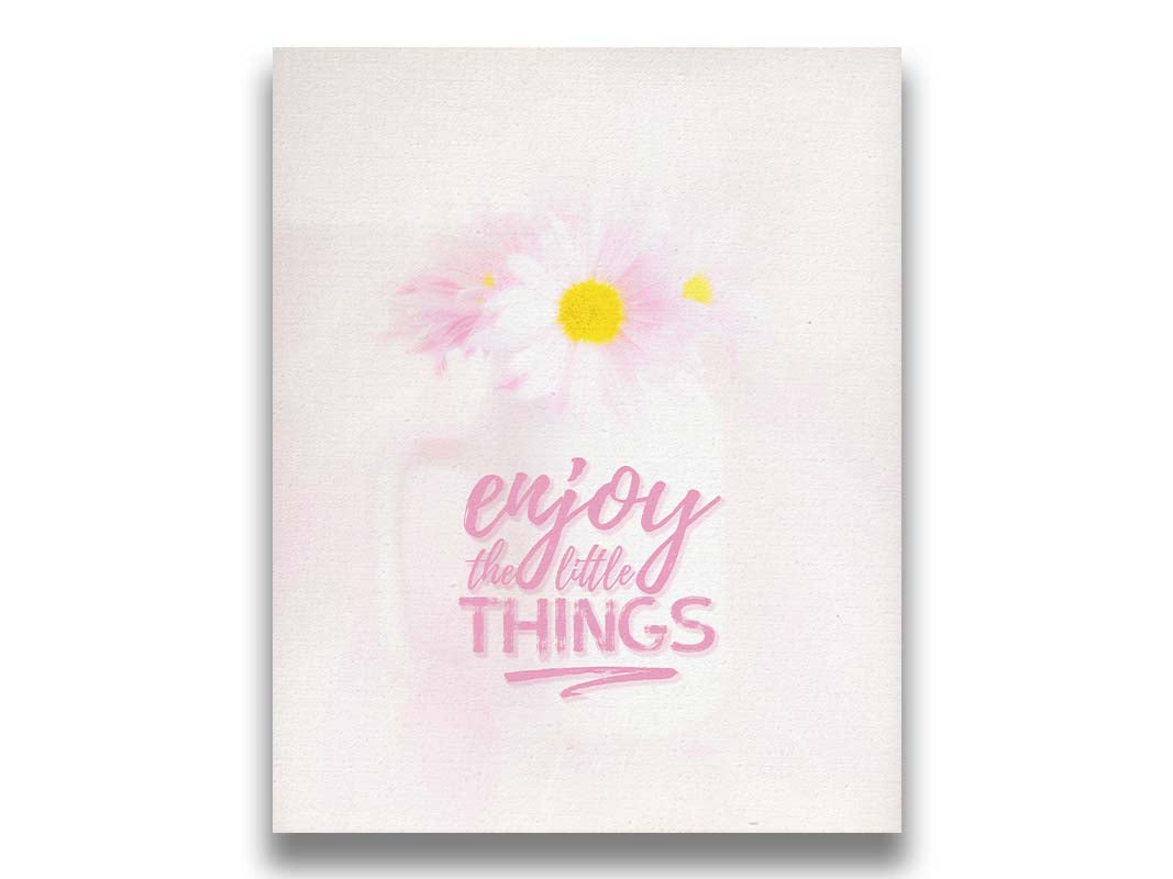 A photo of a white vase with pink daisies in a soft pink background, superimposed with the phrase "enjoy the little things". Printed on canvas.