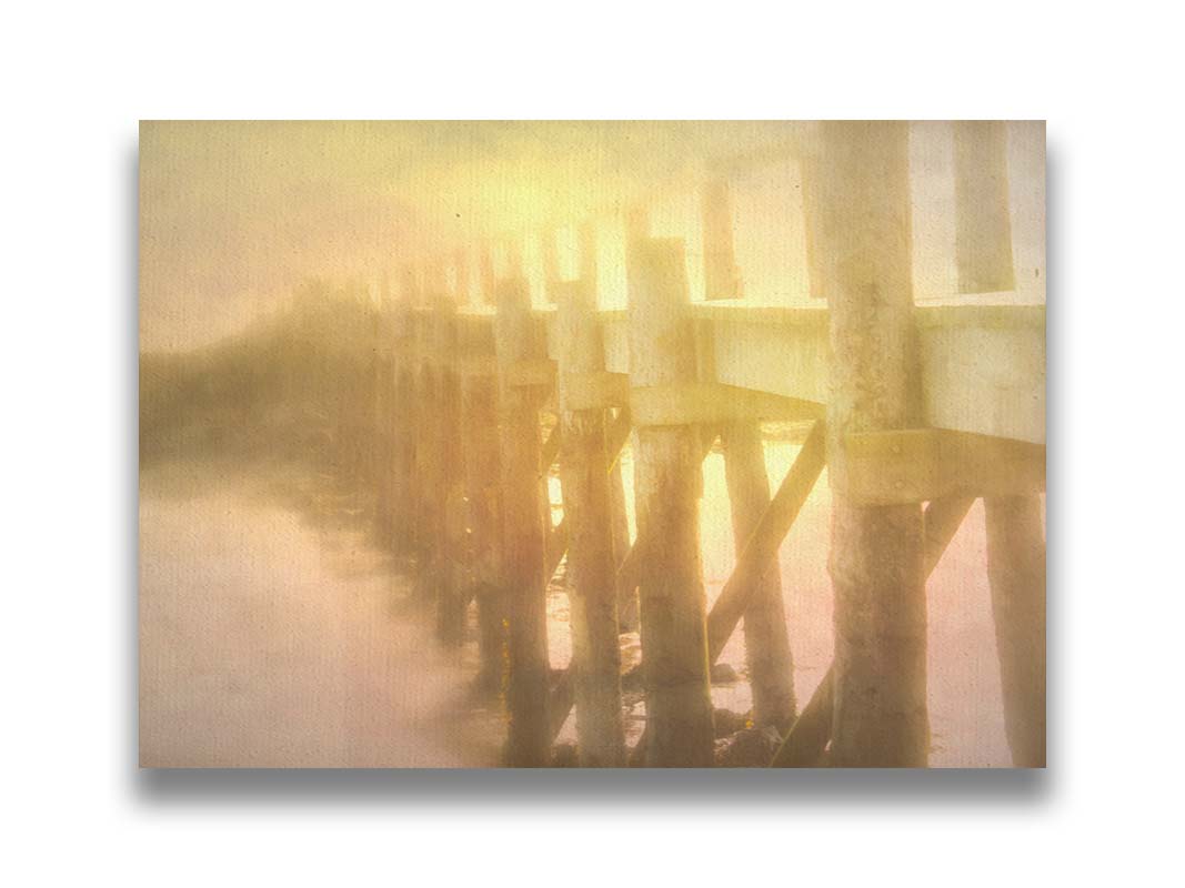 A photo of a pier trailing off into the water, lit by the sunset. Printed on canvas.