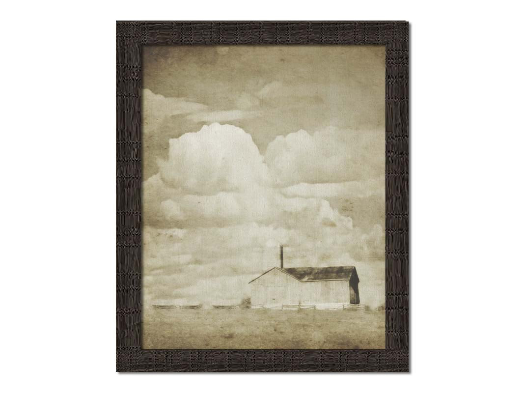 A sepia photo of a barn under a wide, open sky with large, fluffy clouds. Printed on canvas and framed.