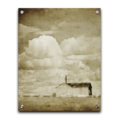 A sepia photo of a barn under a wide, open sky with large, fluffy clouds. Printed on acrylic.