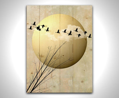 A photo collage art piece of migratory birds flying south for the winter, silhouetted against a big gold moon. Printed on a wood pallet.