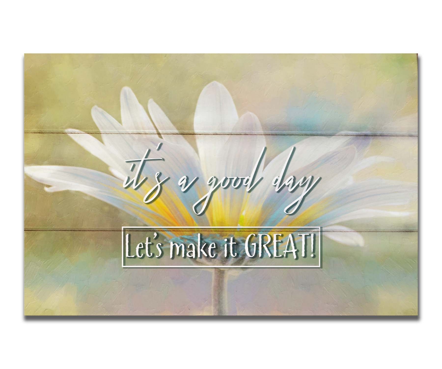 A photo of a white daisy in the sunlight, against a soft green background. It is overlaid with the phrase "It's a good day, let's make it great!" Printed on a box board.