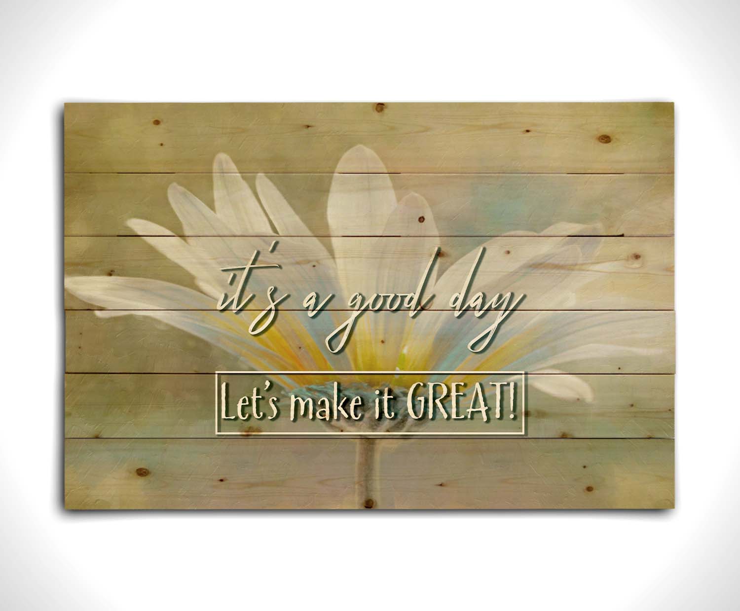 A photo of a white daisy in the sunlight, against a soft green background. It is overlaid with the phrase "It's a good day, let's make it great!" Printed on a wood pallet.