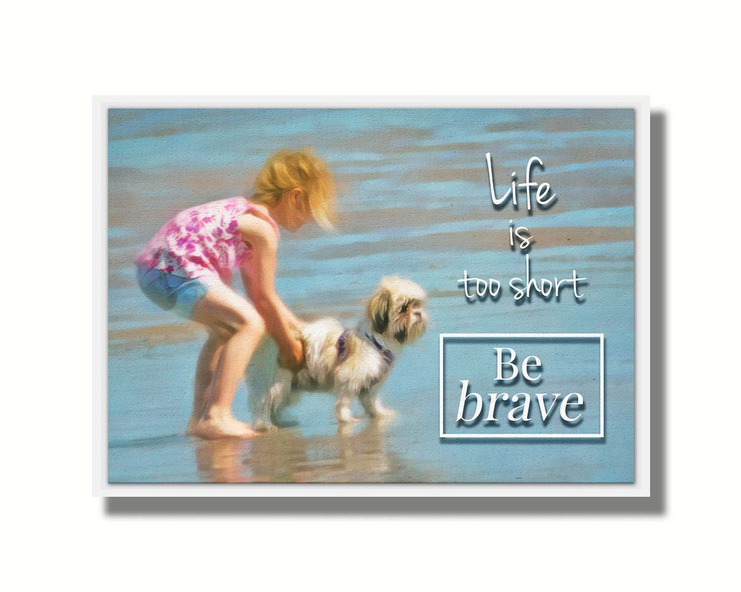 A photograph of a small child and a dog at the beach overlaid with the phrase "life is too short, be brave". Printed on canvas in a float frame.