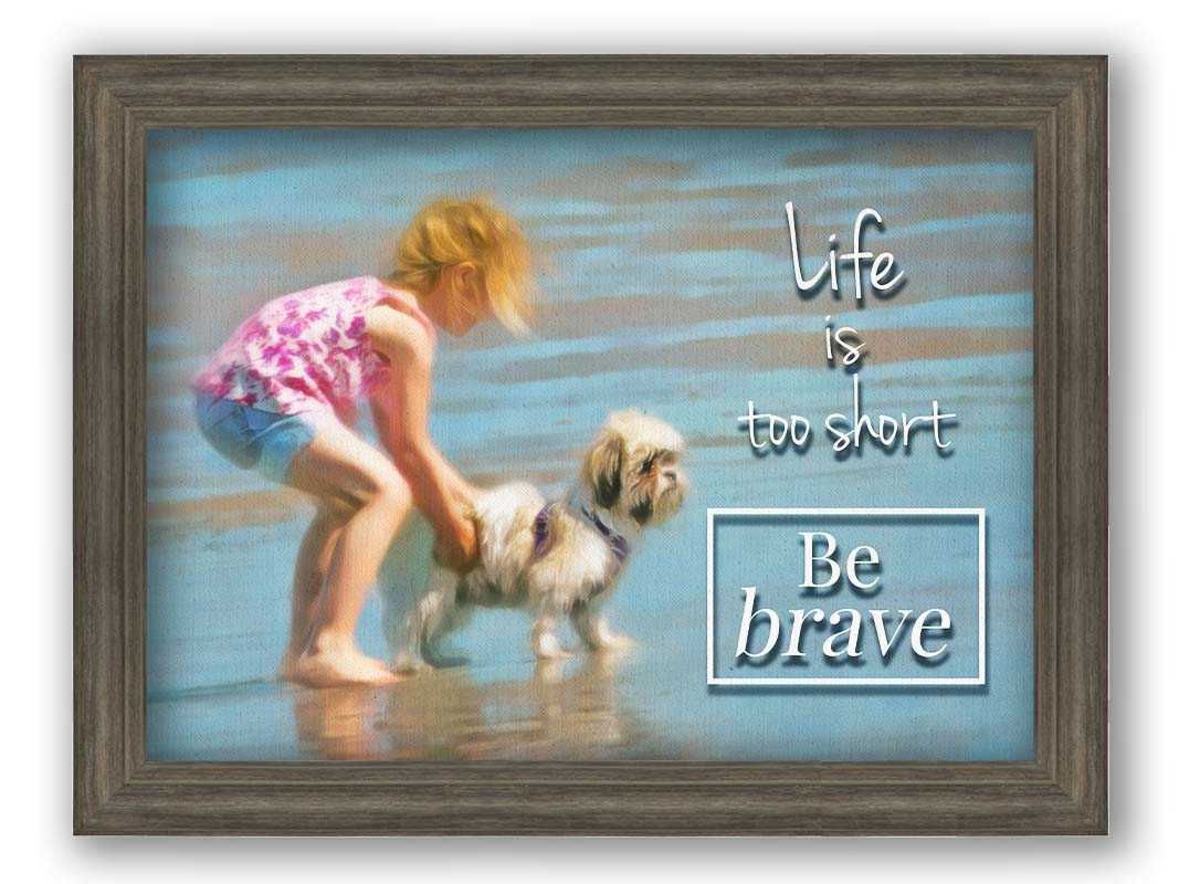 A photograph of a small child and a dog at the beach overlaid with the phrase "life is too short, be brave". Printed on canvas and framed.