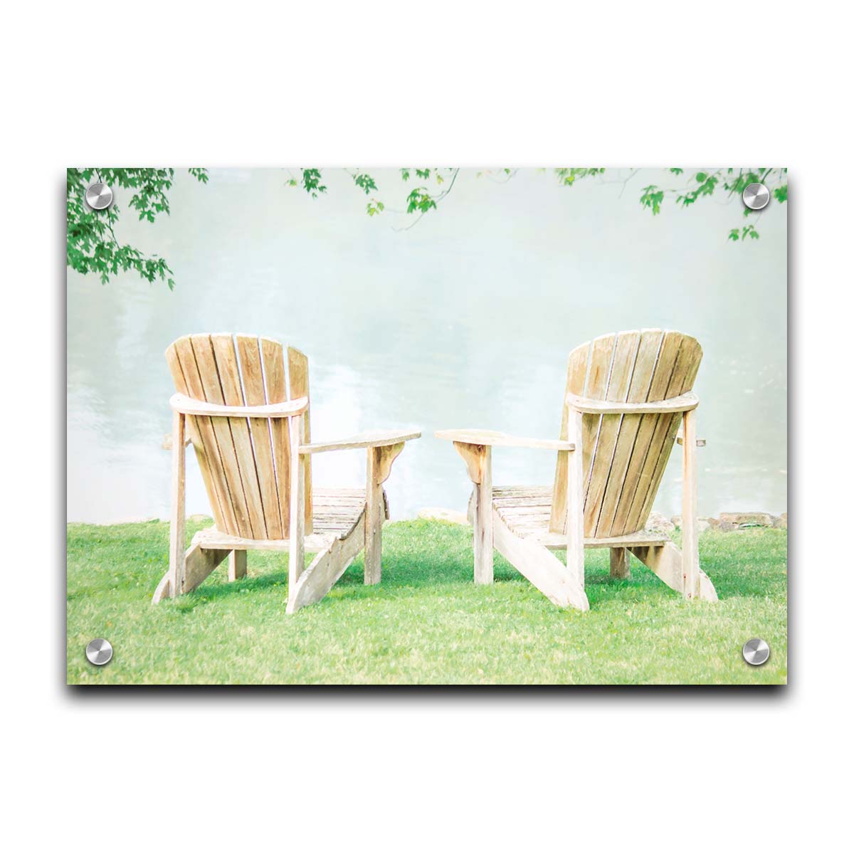 A photo of two wood lawn chairs, sitting on bright green grass, facing a lake. Printed on acrylic.