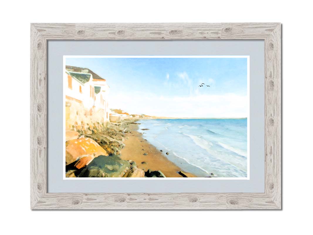 A photo of a beach lined with houses on a calm, sunny day.  Printed on paper, matted, and framed.