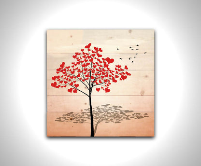 A graphic of a tree with red heart icons for leaves against a white and pink background. Printed on a wood pallet.