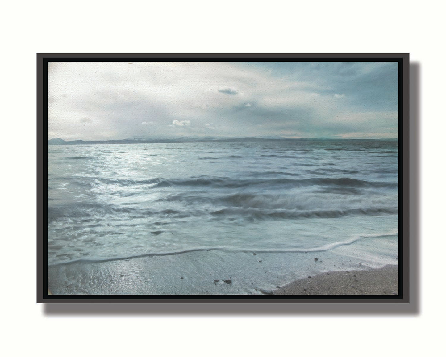 A photo of the sea on a cloudy day, creating a desaturated, stormy look. Printed on canvas in a float frame.