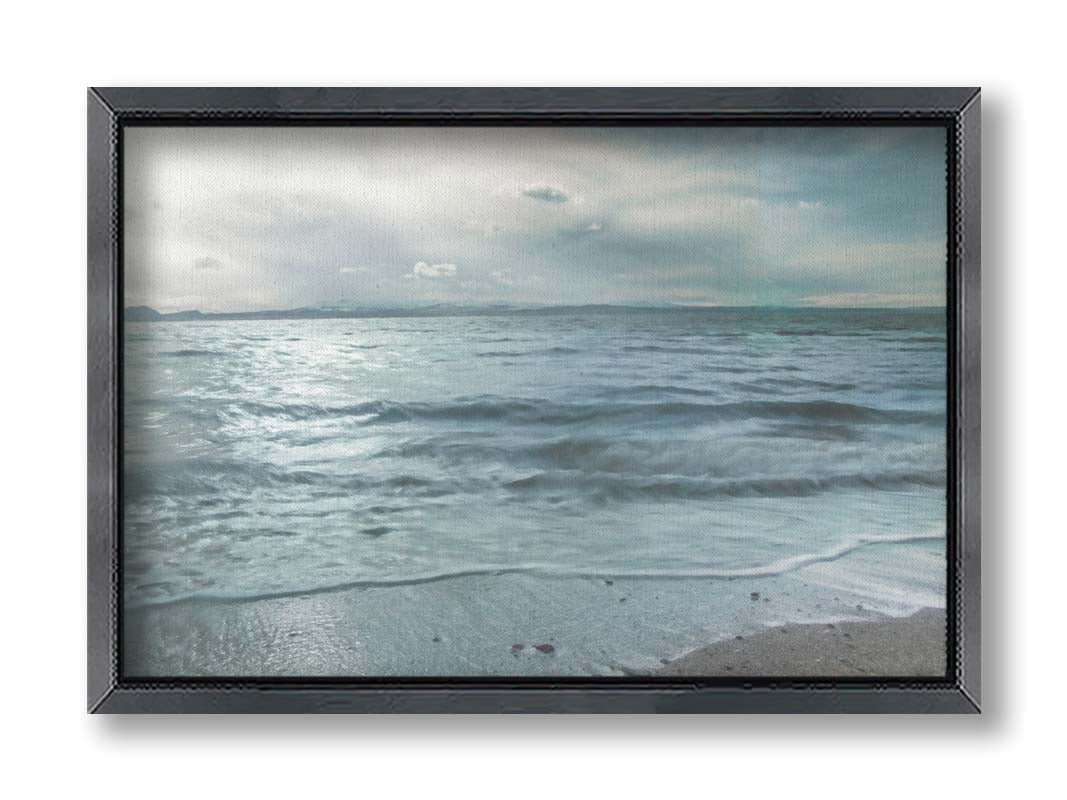 A photo of the sea on a cloudy day, creating a desaturated, stormy look. Printed on canvas and framed.