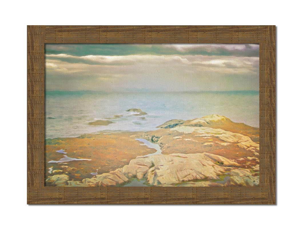 A photo of a stoney shore, looking out to sea under a cloudy sky. Printed on canvas and framed.