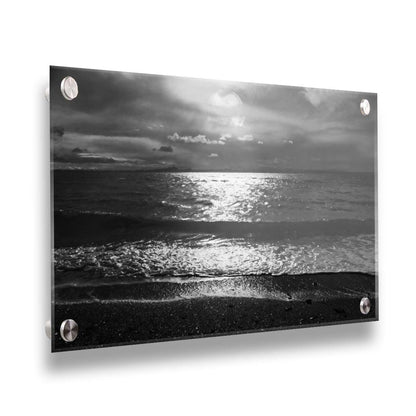 A photograph of the sea at night in grayscale. The light from the moon rerflects off the water in sharp contrast through the darkness of night. Printed on acrylic.