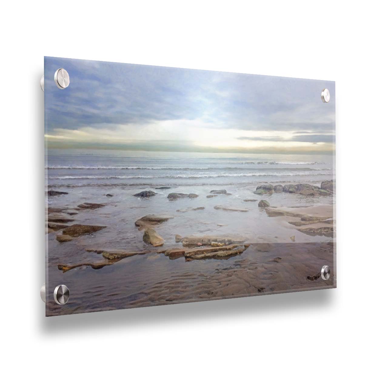 A photograph of the rocky shore of the North Sea at low tide. The sun peeks over the horizon through the partly cloudy sky. Printed on acrylic.