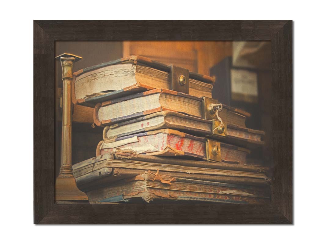 A photo of a stack of worn books, many bound shut by brassy locks. Printed on canvas and framed.