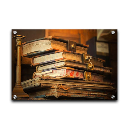 A photo of a stack of worn books, many bound shut by brassy locks. Printed on acrylic.