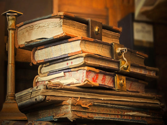 A photo of a stack of worn books, many bound shut by brassy locks.