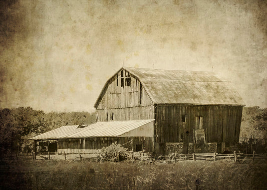 A sepia photo of a large, old, leaning barn. 
