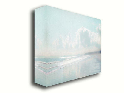 A photo of a beach on a bright but foggy day. The light reflects on the wet sand with the color of the sky,, adding to the dreamlike appearance. A city can be seen through the fog in the distance. Printed on canvas.