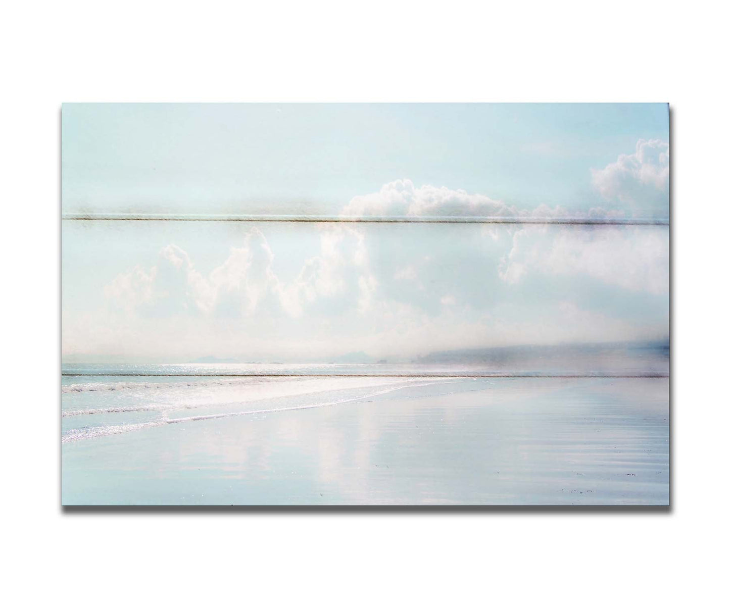 A photo of a beach on a bright but foggy day. The light reflects on the wet sand with the color of the sky,, adding to the dreamlike appearance. A city can be seen through the fog in the distance. Printed on a box board.