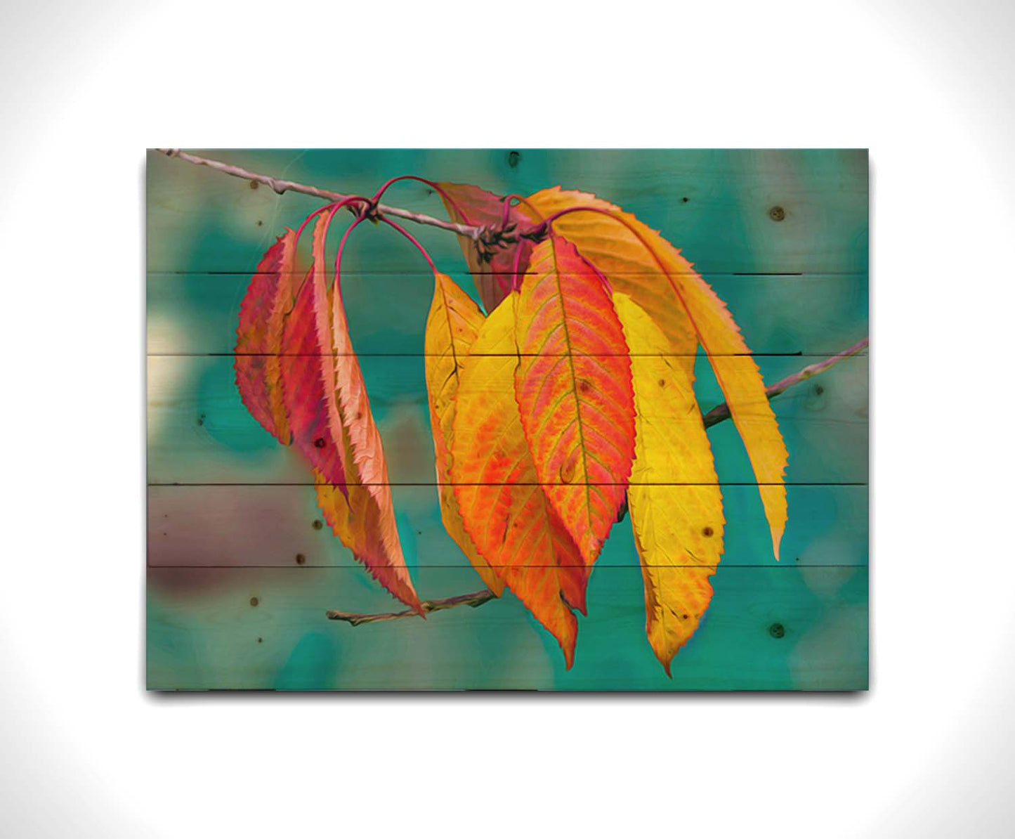 A photo of a twig of red and yellow leaves, with a blue background blurred with perspective. Printed on a wood pallet.