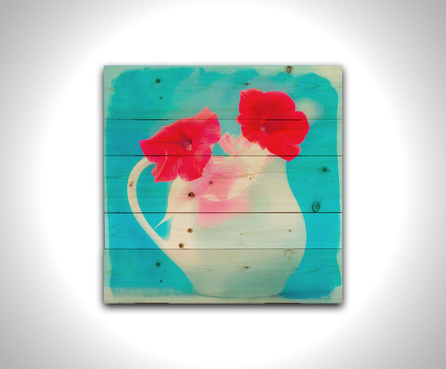 A photo of two red flowes in a white pitcher vase against a cyan backgrround. Printed on a wood pallet.