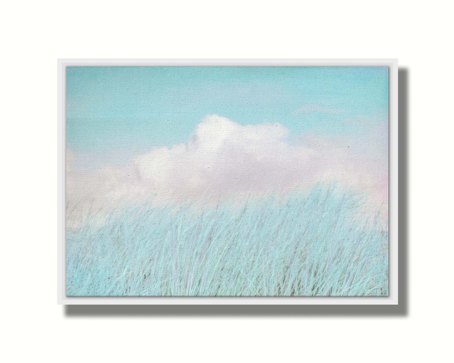 A photo of tall grass under a blue sky with white clouds. Printed on canvas in a float frame.