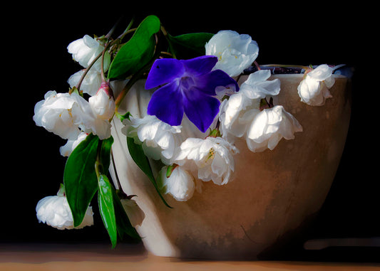 A photo of a brown bowl of white and purple flowers, edited to have a painterly quality.