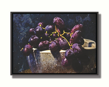 A photo of a bunch of purple grapes in a bowl, covered in drops of water and overlayed with textues. Printed on canvas in a float frame.