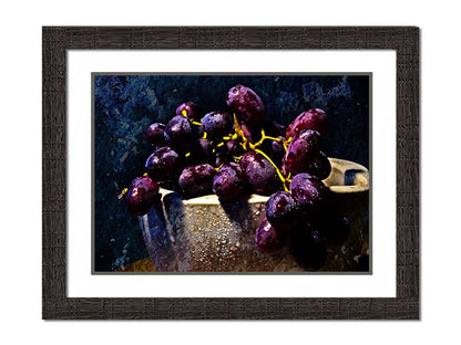 A photo of a bunch of purple grapes in a bowl, covered in drops of water and overlayed with textues. Printed on paper, matted, and framed.