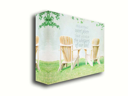 A photo of two wood lawn chairs, sitting on bright green grass, facing a lake. It is overlaid with the phrase, "It is in that quiet place that we hear the whispers of our soul." Printed on canvas.