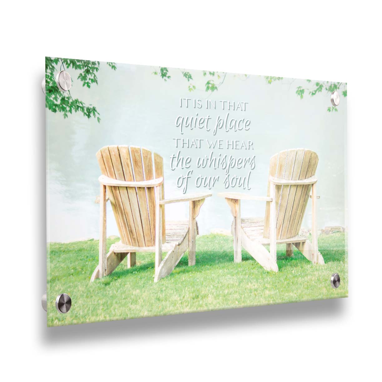 A photo of two wood lawn chairs, sitting on bright green grass, facing a lake. It is overlaid with the phrase, "It is in that quiet place that we hear the whispers of our soul." Printed on acrylic.