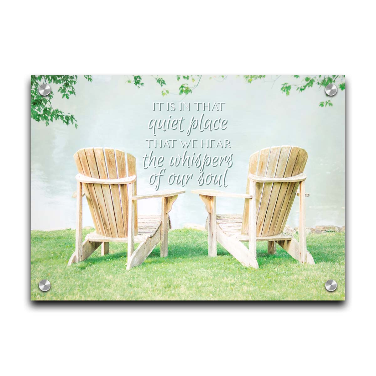 A photo of two wood lawn chairs, sitting on bright green grass, facing a lake. It is overlaid with the phrase, "It is in that quiet place that we hear the whispers of our soul." Printed on acrylic.