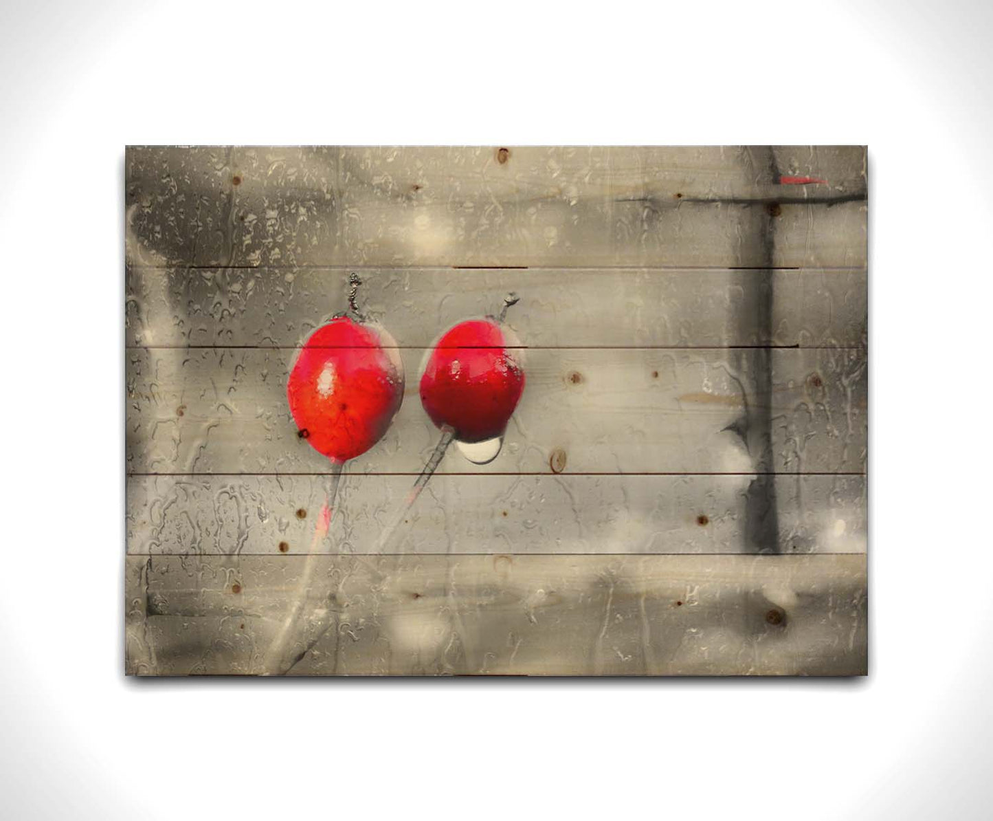 A photo of two red berries, covered in water from the rain, in grayscale with red spot color. It is overlayed with a texture of wet glass. Printed on a wood pallet.