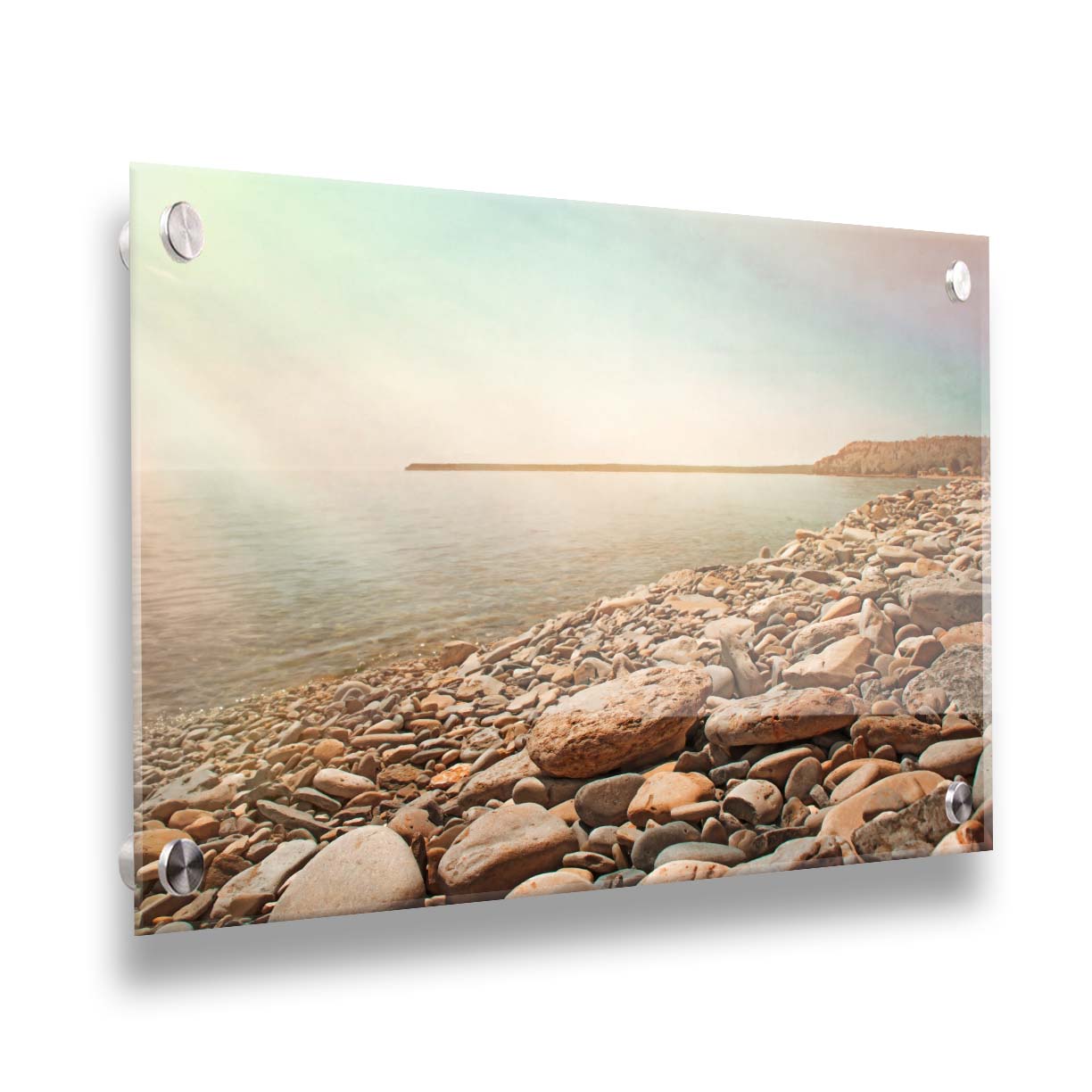 A warm-colored photograph of a rocky beach in the sunlight, bathed in a spectrum of colors. Printed on acrylic.