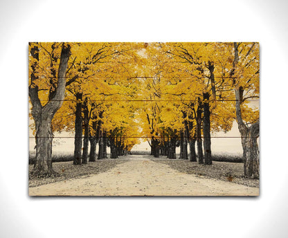 A photo of a road bordered by lines of trees, and surrounded by fields of crops. Edited in black and white, with selectively colored yellow leaves. Printed on a wood pallet.