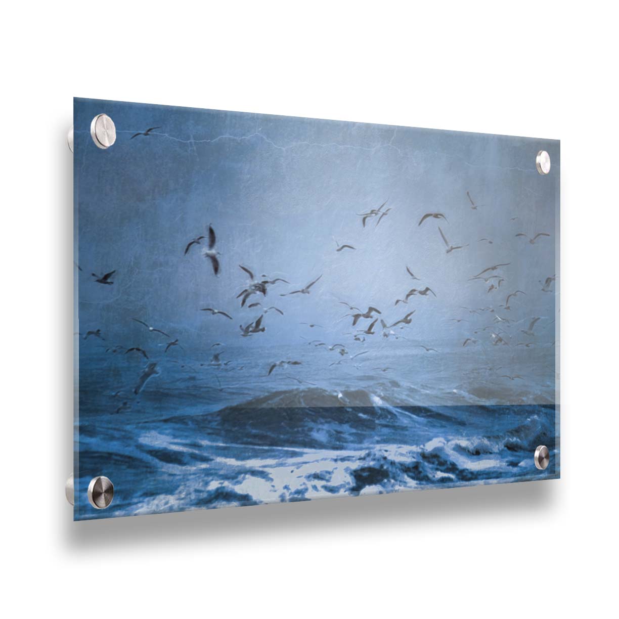 An edited photo of a flock of seagulls swarming over the sea in search of food, as the sky darkens and the waves pick up with an oncoming storm. Printed on acrylic.