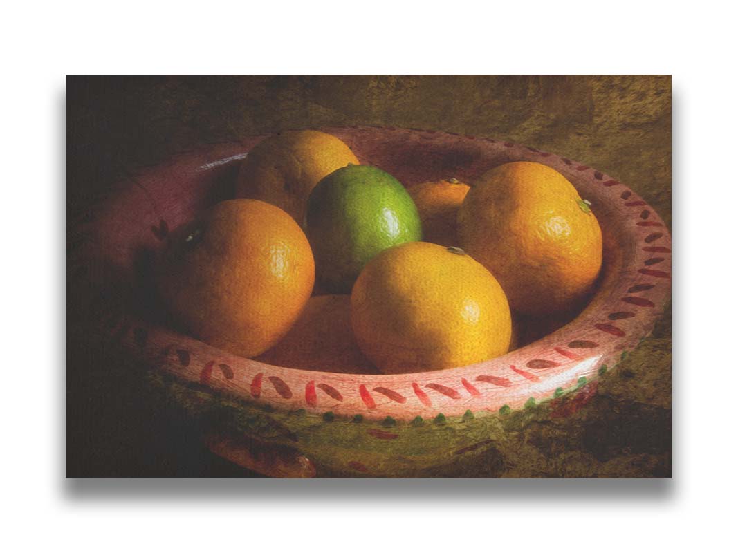 A photo of a bowl of oranges, with one lime placed in the center. Printed on canvas.