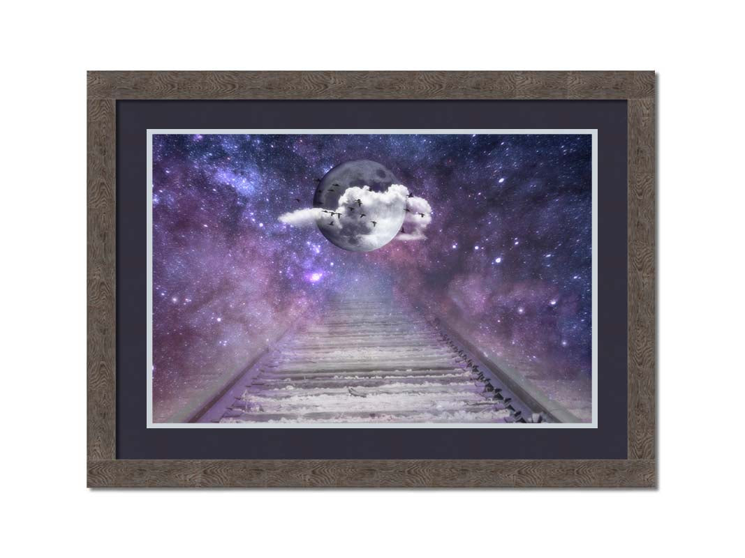 An edited photo looking down train tracks, leading into a starry space view. In the center is a moon surrounded by wispy clouds, with silhouetted geese flying across it. Printed on paper, matted, and framed.