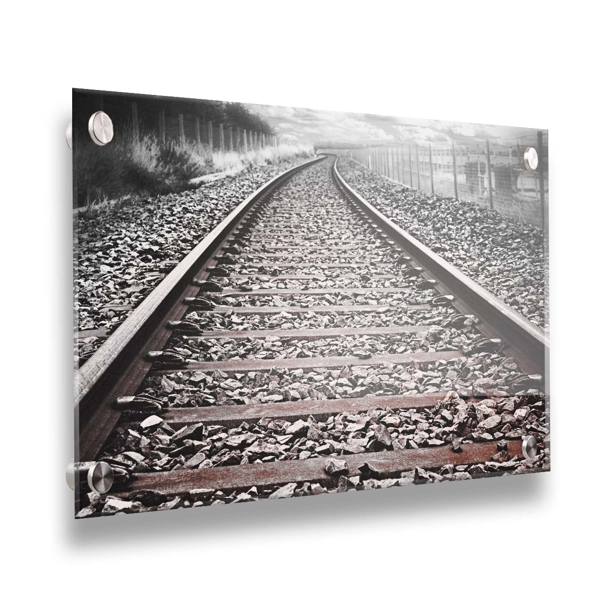 A photo looking down train tracks in black and white, with tinges of red-brown spot color. Printed on acrylic.